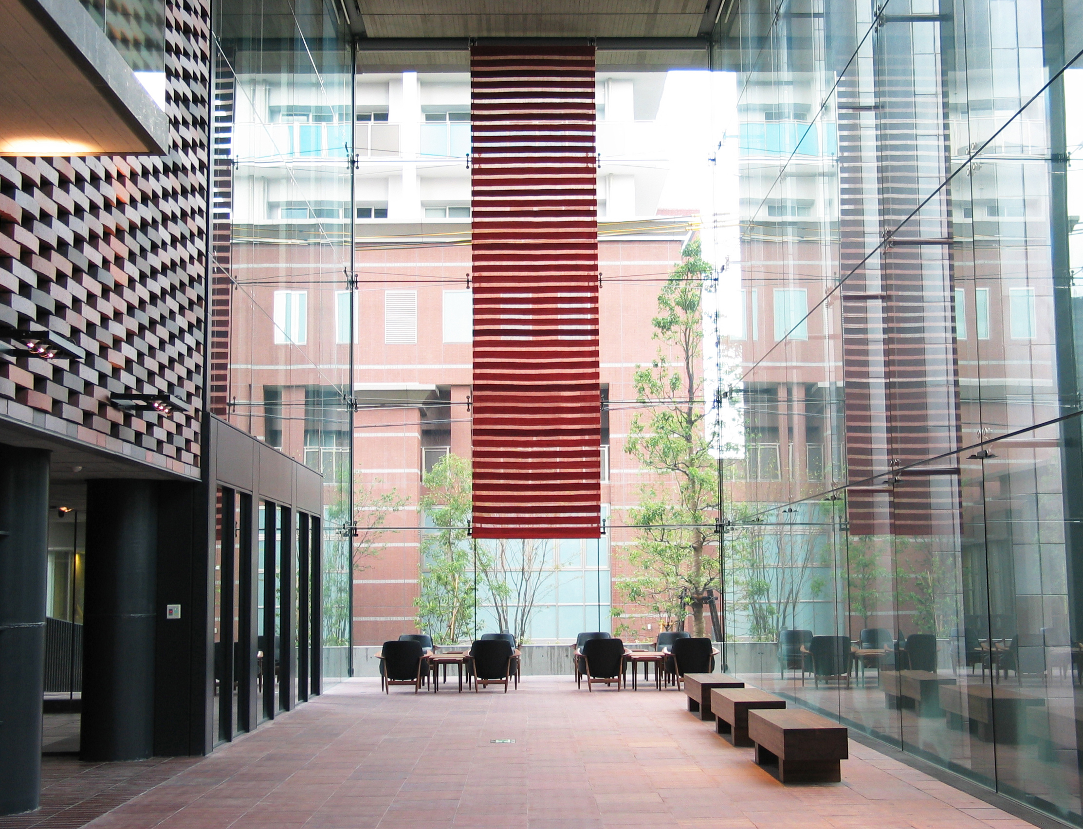 天井から吊られた赤のロゴバキリムのタペストリーの写真