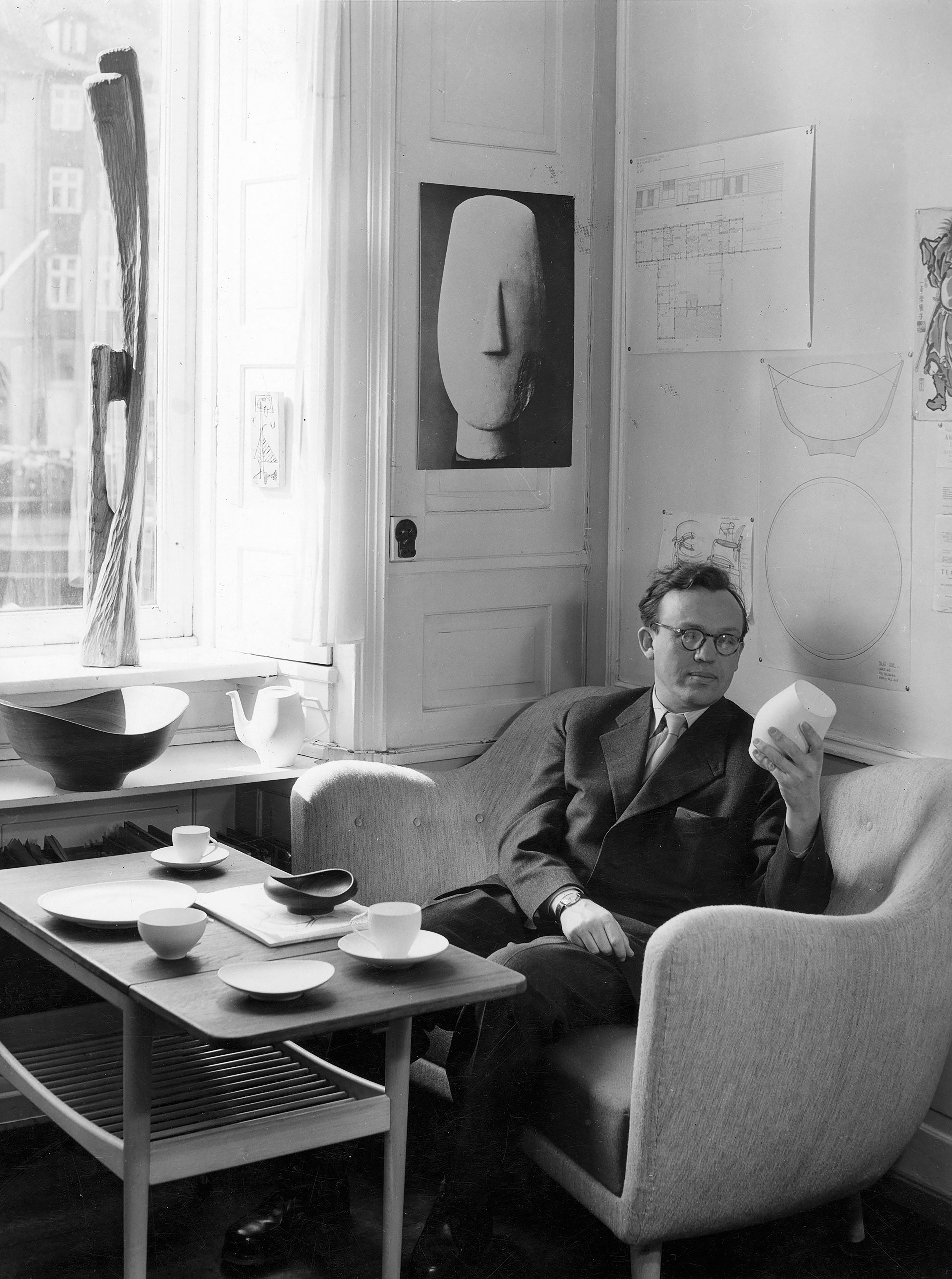 ソファに座り食器を眺めているフィン・ユールの写真