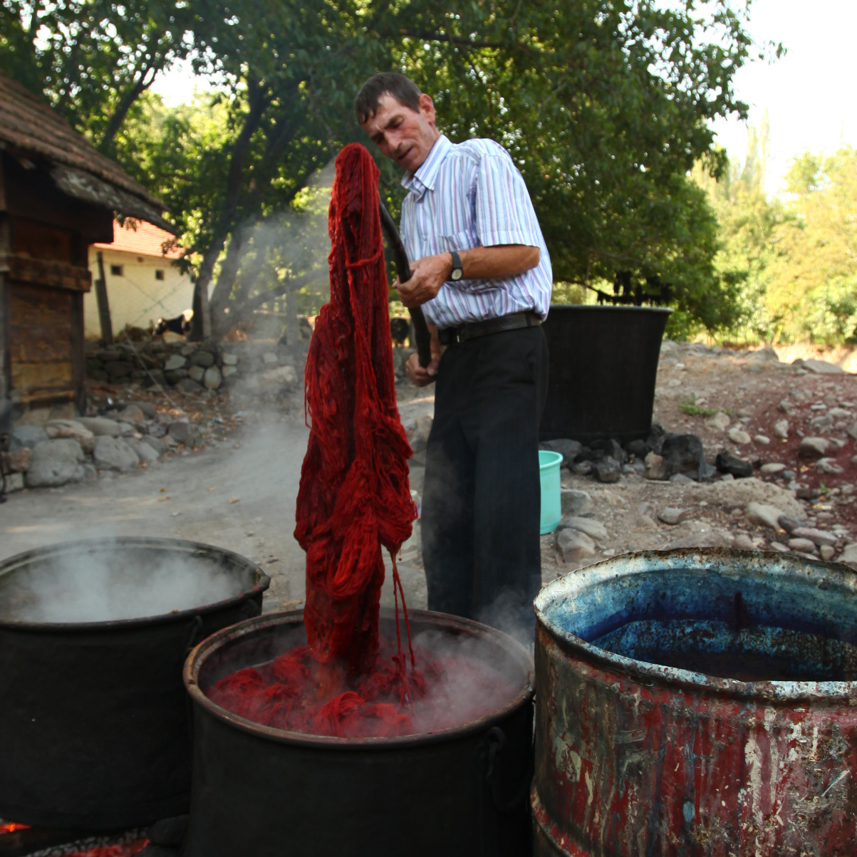 草木染めで糸を染めている男性の写真