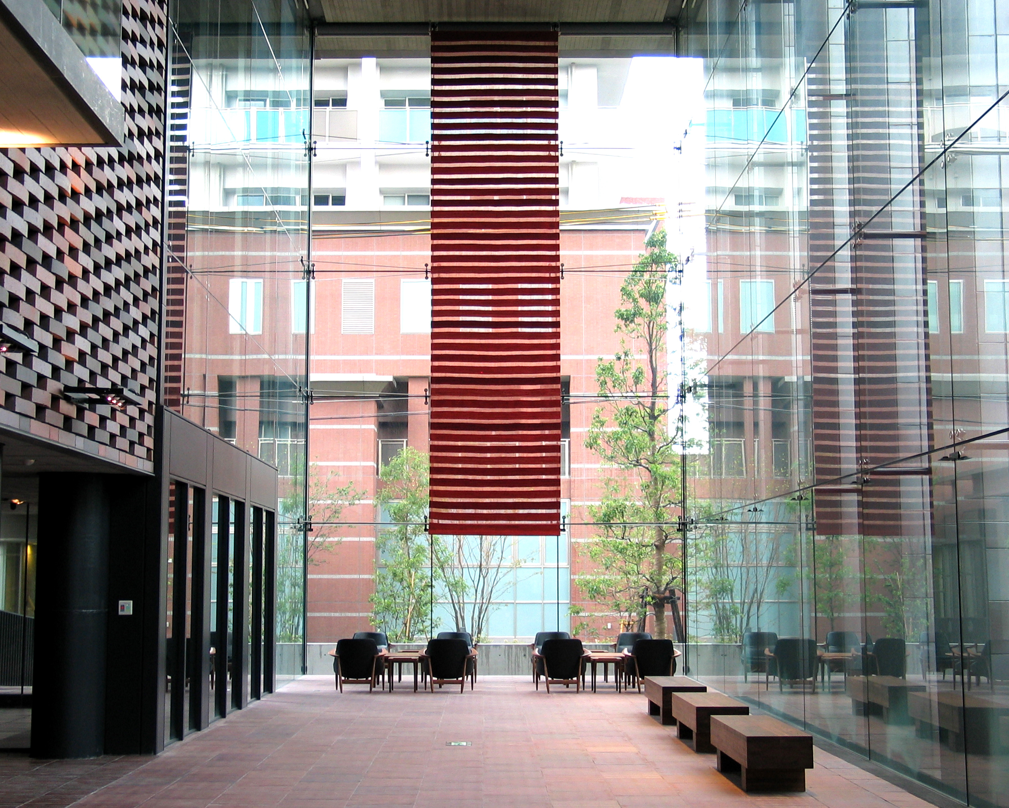 天井に吊られた赤のロゴバキリムのタペストリーの写真