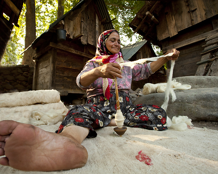 コマを使い糸を紡いでいる女性の写真2